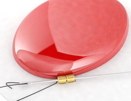 Pinkish cabochon with gold beads on a needle